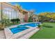 Luxurious pool and spa area with lush landscaping surrounding a beautiful home at 1549 Foothills Village Dr, Henderson, NV 89012