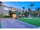 Elegant home with stone accents, lush landscaping, and a brick driveway at 1549 Foothills Village Dr, Henderson, NV 89012