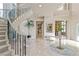 Grand foyer with a winding staircase, marble floors, and elegant decor at 1549 Foothills Village Dr, Henderson, NV 89012