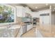 Gourmet kitchen with stone countertops, stainless steel appliances, and garden view at 1549 Foothills Village Dr, Henderson, NV 89012