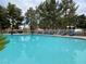 A community swimming pool surrounded by lawn chairs and lush green trees at 2851 S Valley View Blvd # 1195, Las Vegas, NV 89102