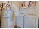 Stackable washer and dryer in a dedicated laundry room with shelving and water heater at 2983 Juniper Hills Blvd # 102, Las Vegas, NV 89142