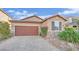 Single-story home with brown garage door, stone accents, and landscaped yard at 5344 Bocopa St, Las Vegas, NV 89148