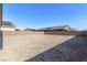 Large undeveloped backyard with block wall and views of neighborhood homes and blue sky at 6524 Summershade St, North Las Vegas, NV 89086