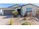 Charming home exterior with a well-maintained front yard with desert landscaping and a gray two-car garage at 6524 Summershade St, North Las Vegas, NV 89086