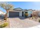 A well-manicured front yard leads up to this home with a gray two-car garage and inviting front entry at 6524 Summershade St, North Las Vegas, NV 89086