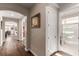 Hallway featuring wood floors, arched entryways, and white trim leading to a bathroom and dining area at 6524 Summershade St, North Las Vegas, NV 89086