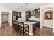 Modern kitchen with a center island, breakfast bar seating, and dark cabinetry at 6524 Summershade St, North Las Vegas, NV 89086