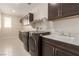 Bright laundry room with upper and lower cabinets, long countertop space, a sink, and front load washer and dryer at 6524 Summershade St, North Las Vegas, NV 89086