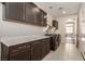This laundry room features tile floors, ample cabinet space, a long countertop and front load washer and dryer at 6524 Summershade St, North Las Vegas, NV 89086