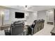 Living room with black reclining furniture and a large TV at 710 Bamboo Bend Pl, Henderson, NV 89011