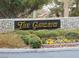 Elegant 'The Gardens' community sign surrounded by lush greenery and stone, creating a welcoming entrance at 7943 Harbour Towne Ave, Las Vegas, NV 89113