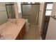 Bathroom with double sink vanity, decorative mirror and glass enclosed shower at 10264 Headrick Dr, Las Vegas, NV 89166