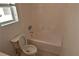 Bright bathroom featuring a tiled shower and toilet, complemented by a window for natural light at 10264 Headrick Dr, Las Vegas, NV 89166