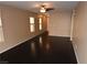 Neutral colored living room with dark hardwood floors and abundant natural light from three windows at 10264 Headrick Dr, Las Vegas, NV 89166