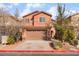 Two-story house with tan exterior, two-car garage, and landscaping at 1512 Groom Ave, North Las Vegas, NV 89081