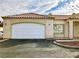 Front view of tan stucco house with tile roof and white garage door at 1900 N Torrey Pines Dr # 132, Las Vegas, NV 89108