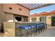 Outdoor kitchen with built-in grill, bar seating, and pergola at 200 W Sahara Ave # 2806, Las Vegas, NV 89102