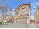 Tan two-story house with attached garage and landscaping at 2505 Cockatiel Dr, North Las Vegas, NV 89084