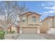 Tan two-story house with attached garage and landscaping at 2505 Cockatiel Dr, North Las Vegas, NV 89084