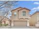 Tan two-story house with attached garage and landscaping at 2505 Cockatiel Dr, North Las Vegas, NV 89084