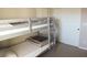 Bedroom with a gray bunk bed featuring white and gray bedding, and two white closet doors at 2509 Piacenza Pl, Henderson, NV 89044