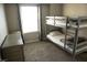 A bedroom featuring bunk beds, a chest, carpeted floor, and a neutral color palette at 2509 Piacenza Pl, Henderson, NV 89044