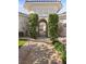 Elegant entryway with arched gate and landscaping at 2575 Grassy Spring Pl, Las Vegas, NV 89135