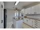 Open kitchen with granite island, white cabinetry, and tile backsplash at 2714 Bridgepointe Dr, Las Vegas, NV 89121