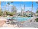 This community pool has lounge chairs, tables, umbrellas, and desert landscaping at 2714 Bridgepointe Dr, Las Vegas, NV 89121