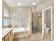 Inviting bathroom featuring tiled bathtub and separate shower, complemented by neutral walls and tile flooring at 278 Iron Duke Ave, Las Vegas, NV 89183