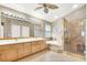 Well-lit bathroom with double vanity, soaking tub, glass enclosed shower and tiled floors at 278 Iron Duke Ave, Las Vegas, NV 89183