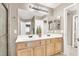 Bathroom featuring dual sinks, white countertop, wooden cabinets, bright lighting, and walk-in shower at 278 Iron Duke Ave, Las Vegas, NV 89183