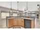 Kitchen island with stainless steel dishwasher, wood cabinetry, tile floors, and view into the living area at 278 Iron Duke Ave, Las Vegas, NV 89183