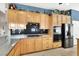 Kitchen featuring granite countertops, wood cabinetry, stainless steel appliances, and a black backsplash at 278 Iron Duke Ave, Las Vegas, NV 89183