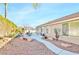 Landscaped backyard with patio, seating area, and gravel pathway at 279 Windsong Echo Dr, Henderson, NV 89012