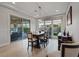 Bright dining room features a wooden table, modern chandelier, and sliding glass doors to backyard at 3018 Fall Solstice Ct, Las Vegas, NV 89138