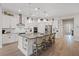 Bright kitchen features a large island, stainless steel appliances, white cabinetry and modern pendant lighting at 3018 Fall Solstice Ct, Las Vegas, NV 89138