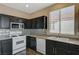 Kitchen with white appliances, dark cabinets, and granite countertops at 3060 Lapis Beach Dr, Las Vegas, NV 89117