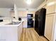 Kitchen with light wood cabinets, black appliances, and wood floors at 3083 Casey Dr # 101, Las Vegas, NV 89120