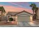 Beige house with a two-car garage and landscaped yard at 3119 Crownline Ct, North Las Vegas, NV 89031