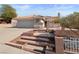 Front yard with a stepped walkway, brick planters, a small tree, and a two-car garage at 3280 James A Bilbray Pkwy, Laughlin, NV 89029