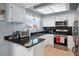 Kitchen with black countertops, white cabinets, stainless steel appliances, and a window overlooking the outside at 3280 James A Bilbray Pkwy, Laughlin, NV 89029