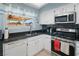 Galley kitchen features black countertops, stainless steel appliances, white cabinets, and a window above the sink at 3280 James A Bilbray Pkwy, Laughlin, NV 89029