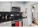 Kitchen with black countertops, white cabinets, stainless steel appliances, and a view into living room at 3280 James A Bilbray Pkwy, Laughlin, NV 89029