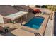 Aerial view of a backyard pool with lounge chairs, covered patio with seating, and meticulously landscaped surroundings at 3280 James A Bilbray Pkwy, Laughlin, NV 89029