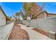 Landscaped backyard with a concrete pathway, gravel, and a block wall at 3708 Penny Cross Dr, North Las Vegas, NV 89032