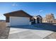 New construction home with a two-car garage and a landscaped yard at 3880 Leonard St, Pahrump, NV 89060