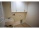 Bright laundry room with white cabinets and utility sink at 3880 Leonard St, Pahrump, NV 89060