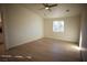 Spacious bedroom with light walls, wood-look floors, and a ceiling fan at 3960 Dart Dr, Pahrump, NV 89060